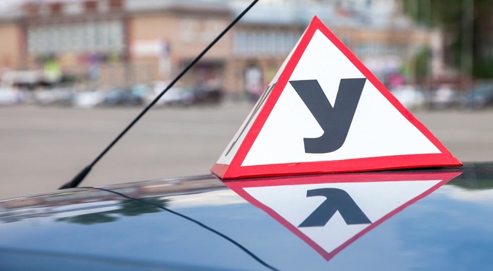 Sign of a Russian Driving School on top of the vehicle