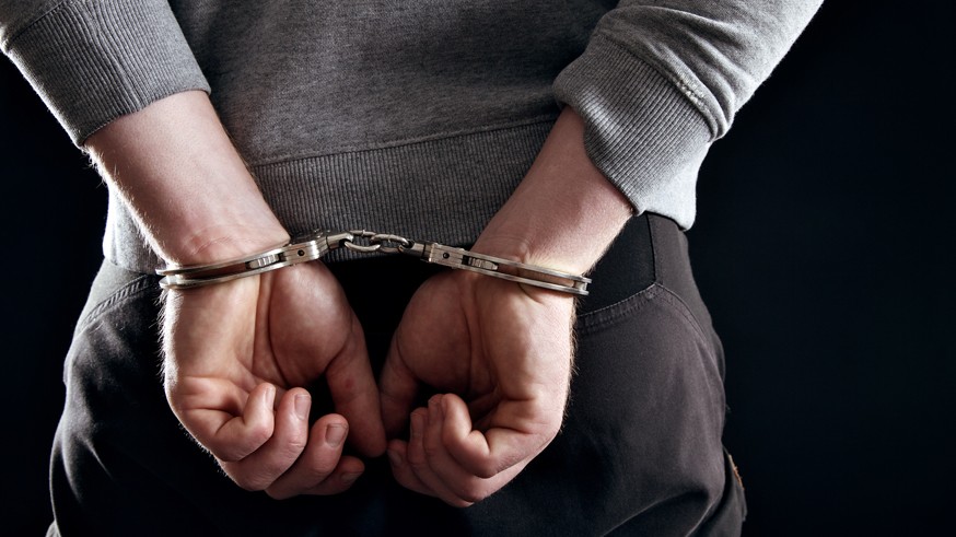 Outlaw's Hands Locked in Handcuffs