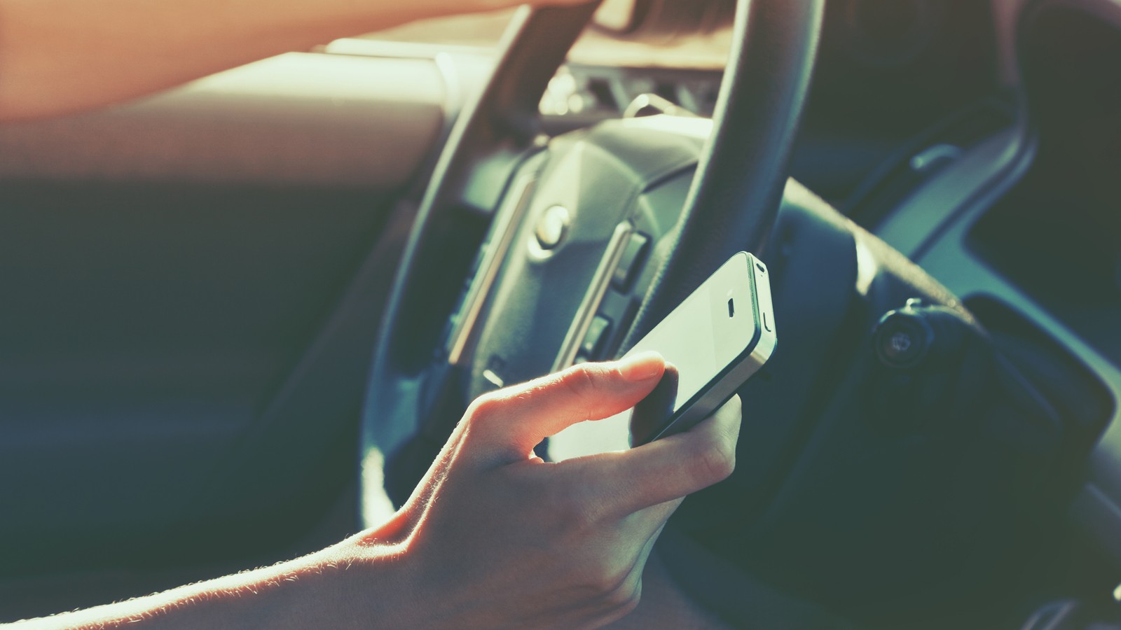 girls hand using smart phone while car driving