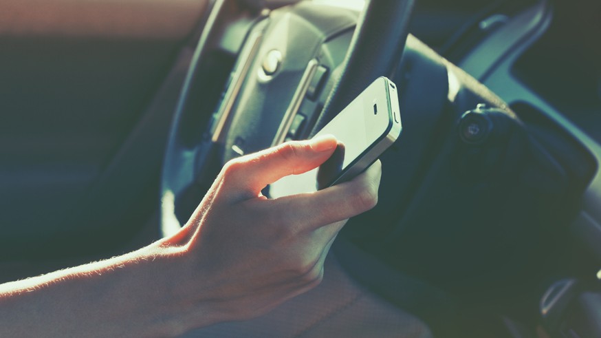 girls hand using smart phone while car driving