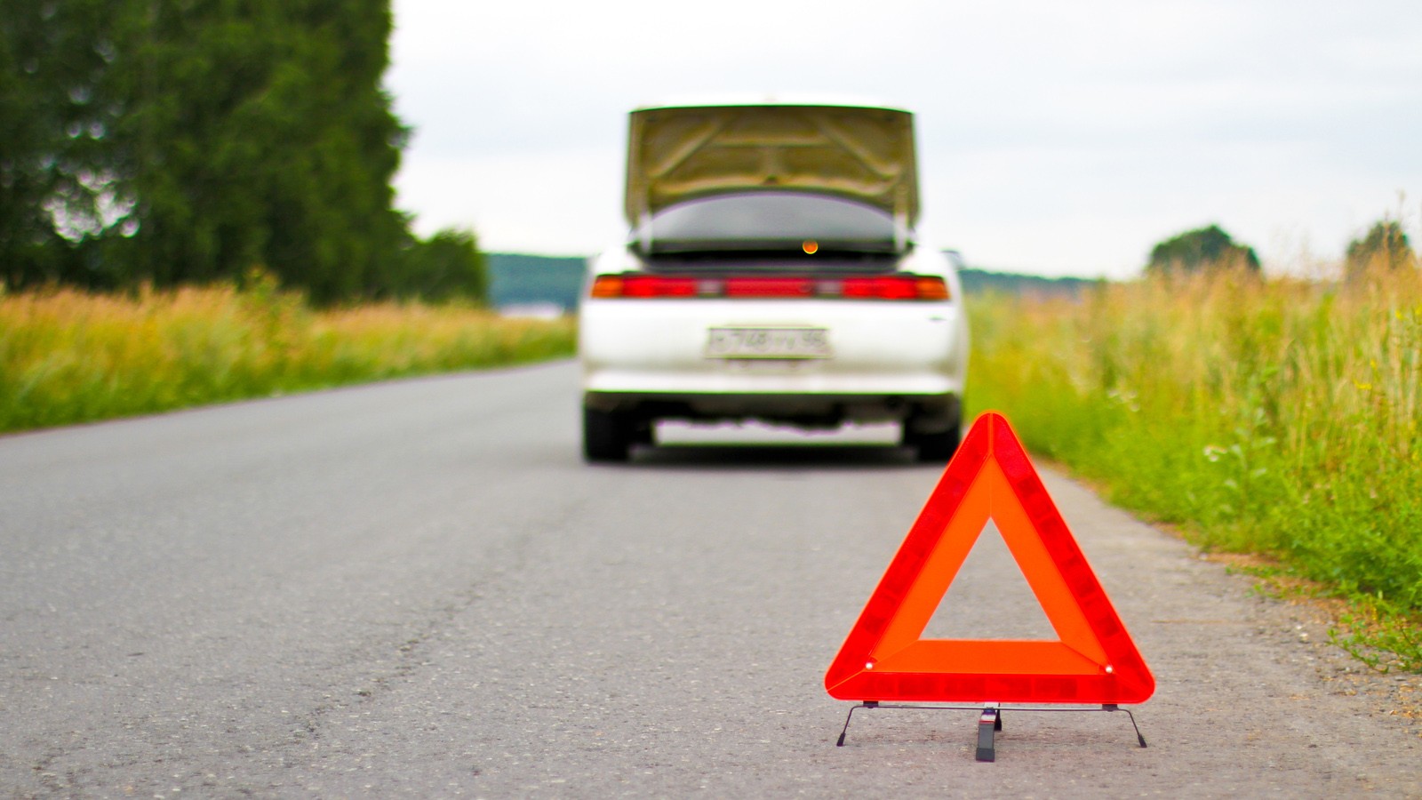 Red warning triangle with a broken down car