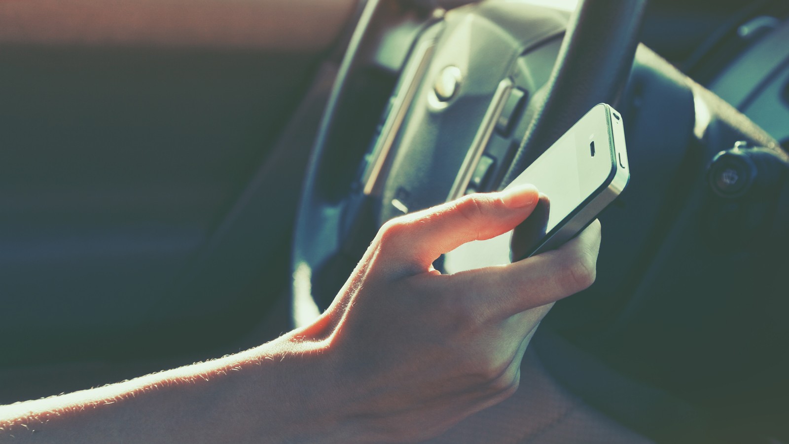girls hand using smart phone while car driving