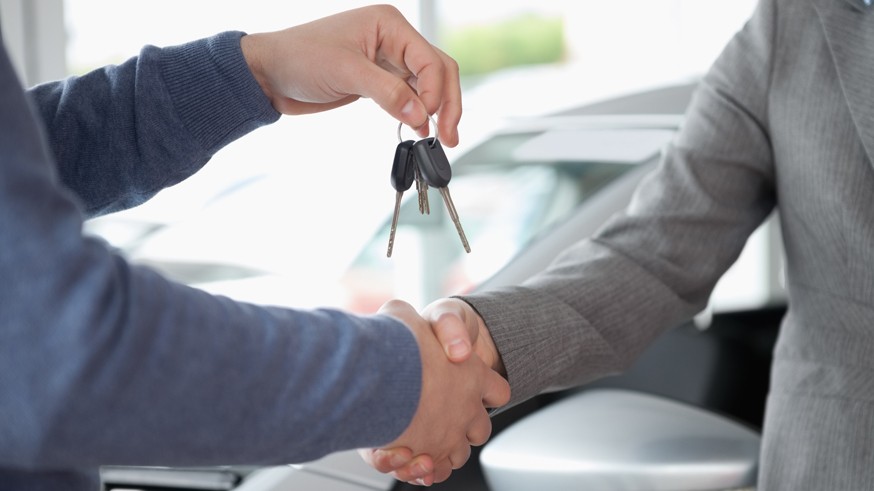 People shaking each other hands while holding keys
