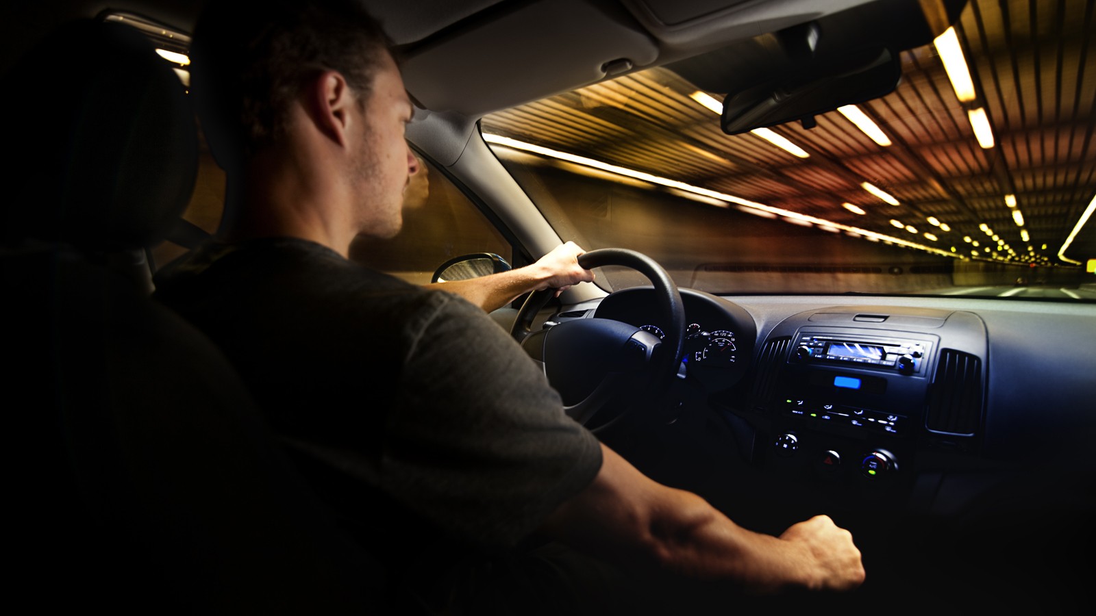 Young Adult Driving Over the Speed Limit in a Tunnel.