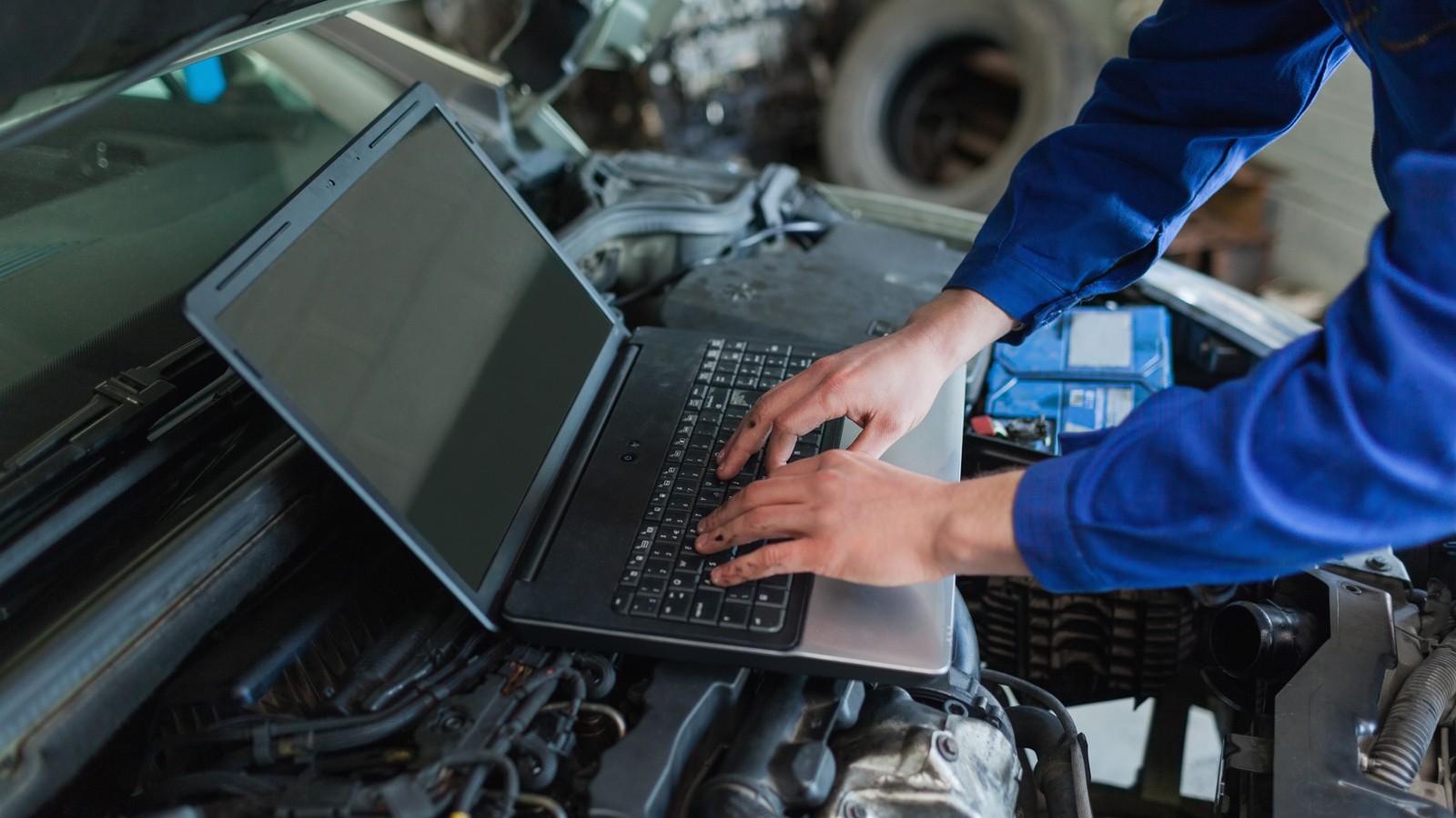 Close-up of auto mechanic using laptop