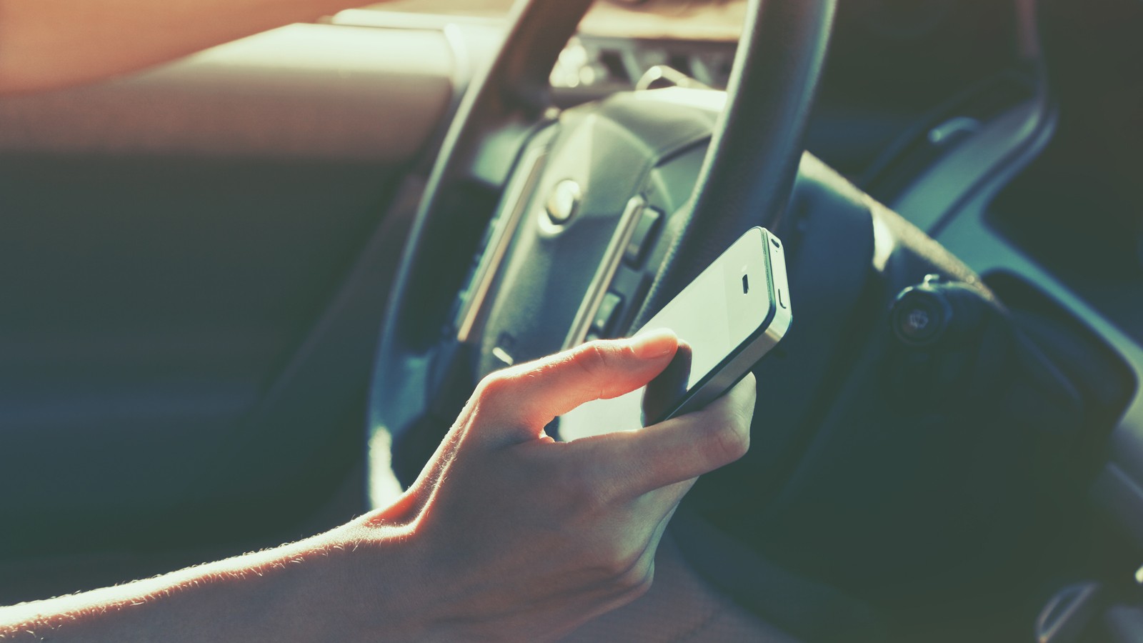 girls hand using smart phone while car driving