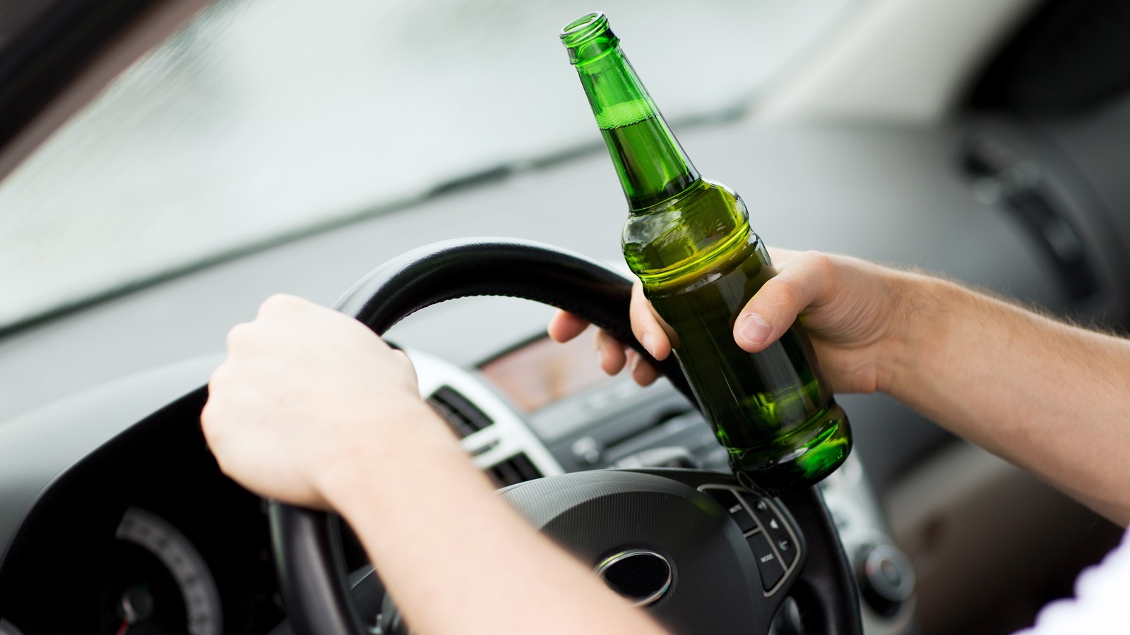 man drinking alcohol while driving the car