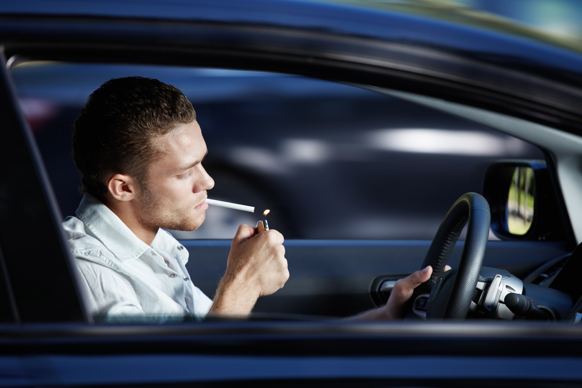 Мужчина курит в машине