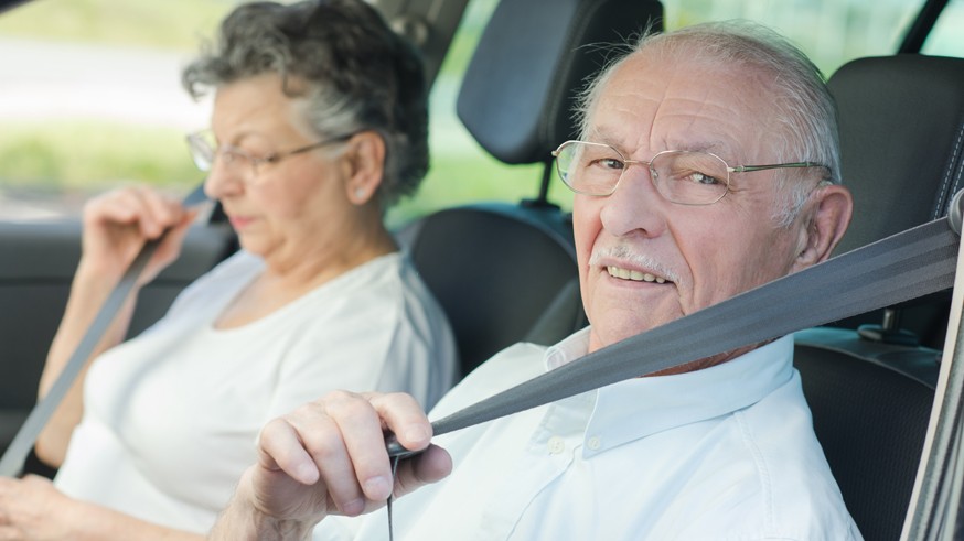 Elderly couple putting on their seatbelts