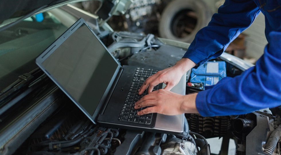Close-up of auto mechanic using laptop
