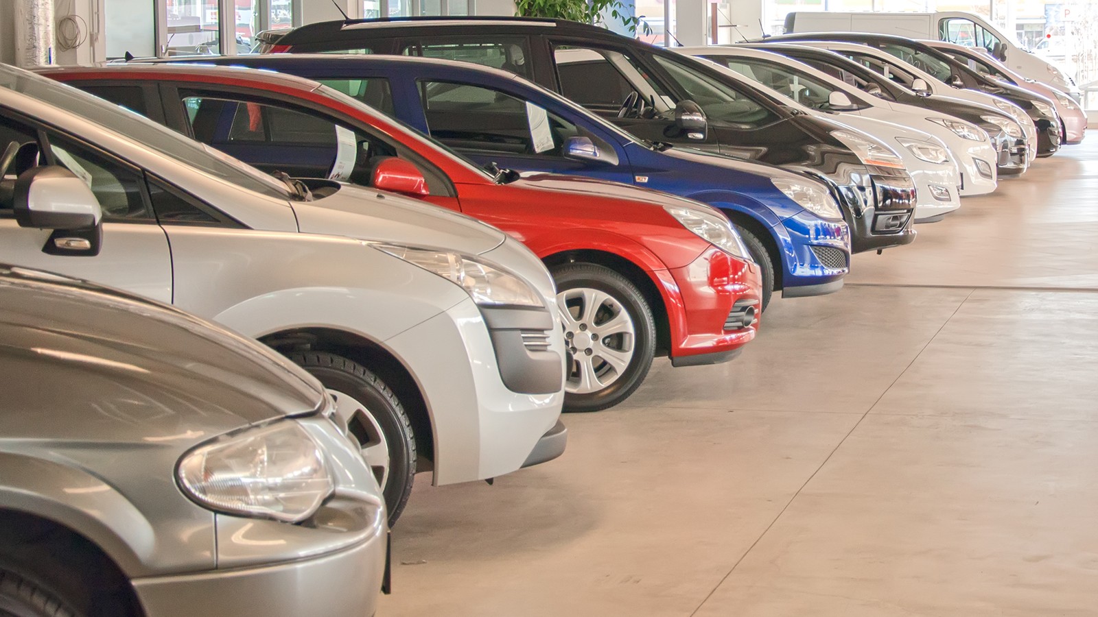 Many cars in parking lot or garage.