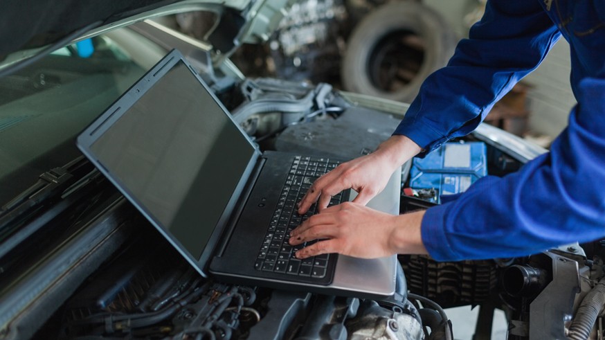 Close-up of auto mechanic using laptop