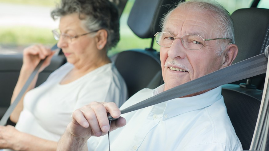 Elderly couple putting on their seatbelts