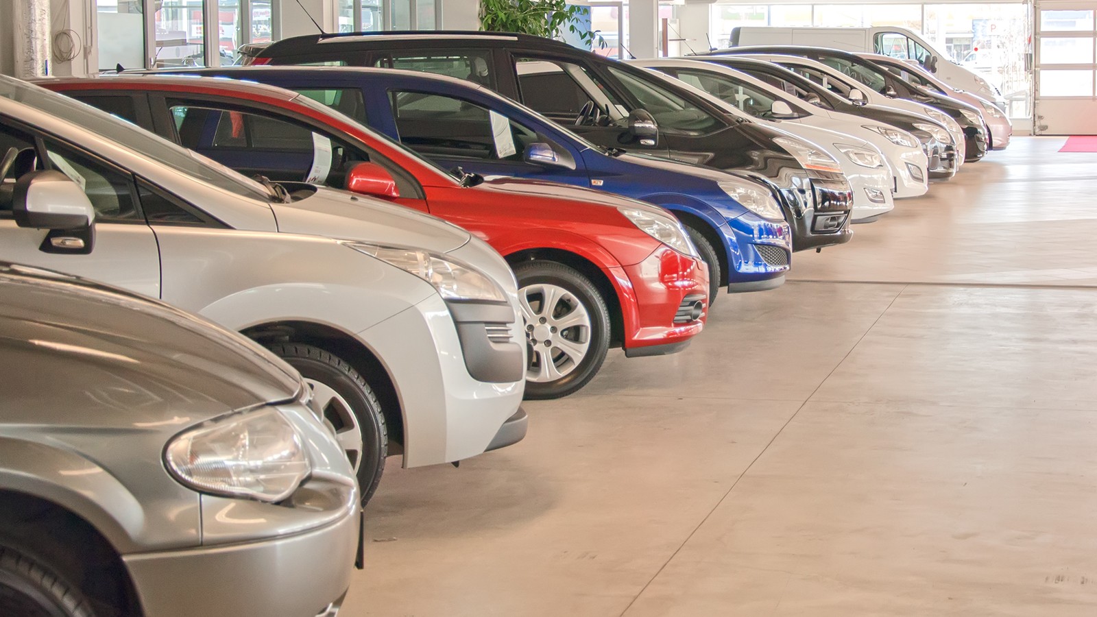 Many cars in parking lot or garage.