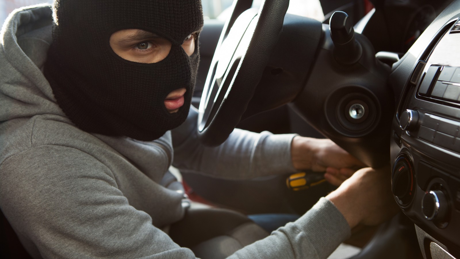 Thief Using Screwdriver In Car