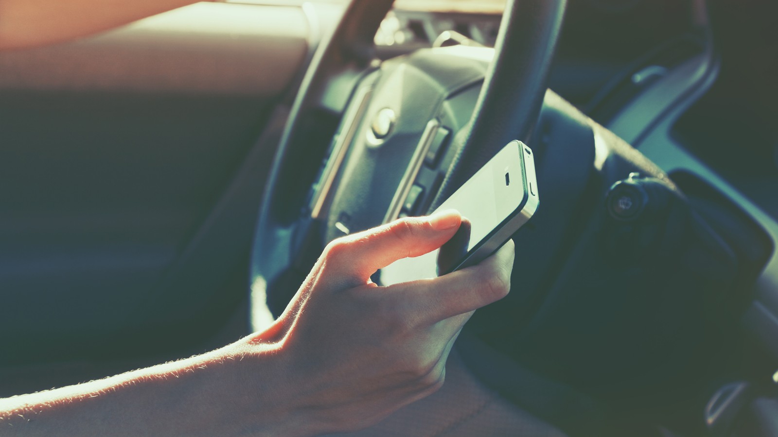 girls hand using smart phone while car driving