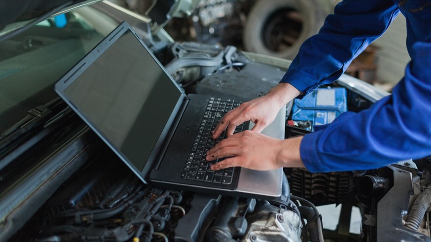 Close-up of auto mechanic using laptop