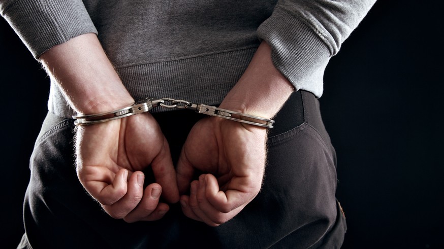 Outlaw's Hands Locked in Handcuffs