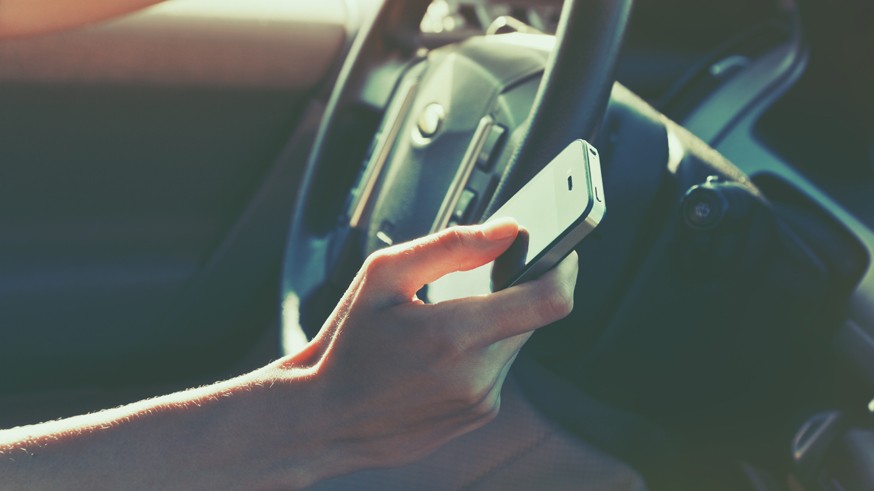 girls hand using smart phone while car driving