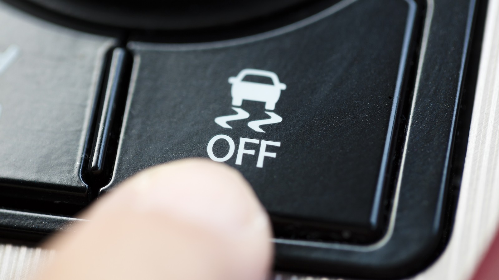 finger pressing Traction Control System button