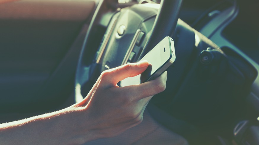 girls hand using smart phone while car driving