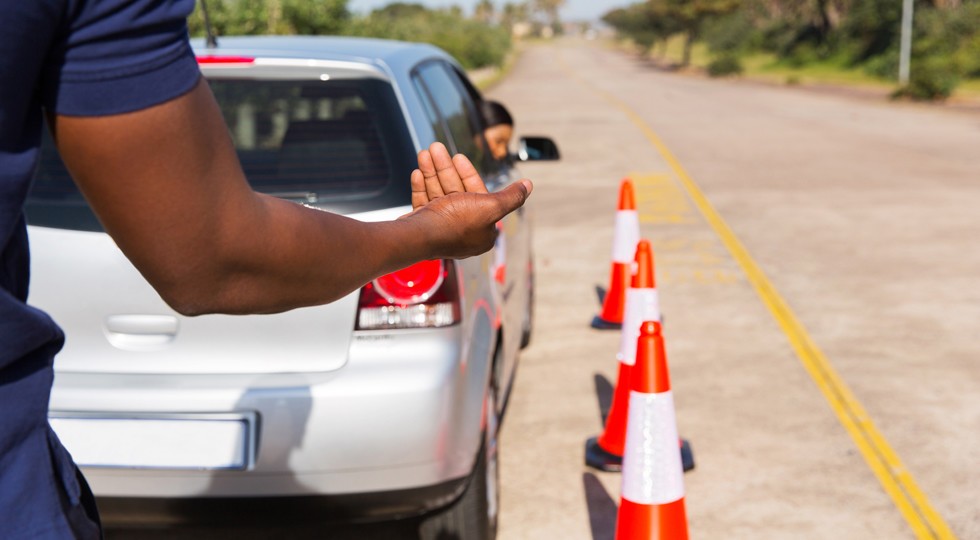driving instructor teaching young girl to reverse