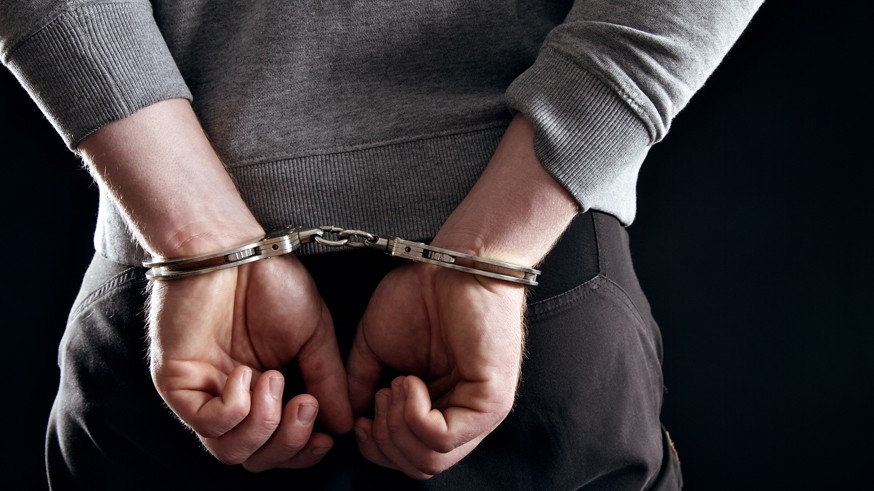 Outlaw's Hands Locked in Handcuffs