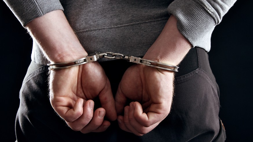 Outlaw's Hands Locked in Handcuffs