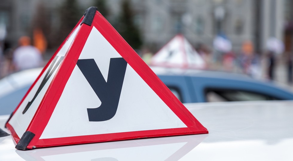 Sign of a Russian Driving School on top of the vehicle
