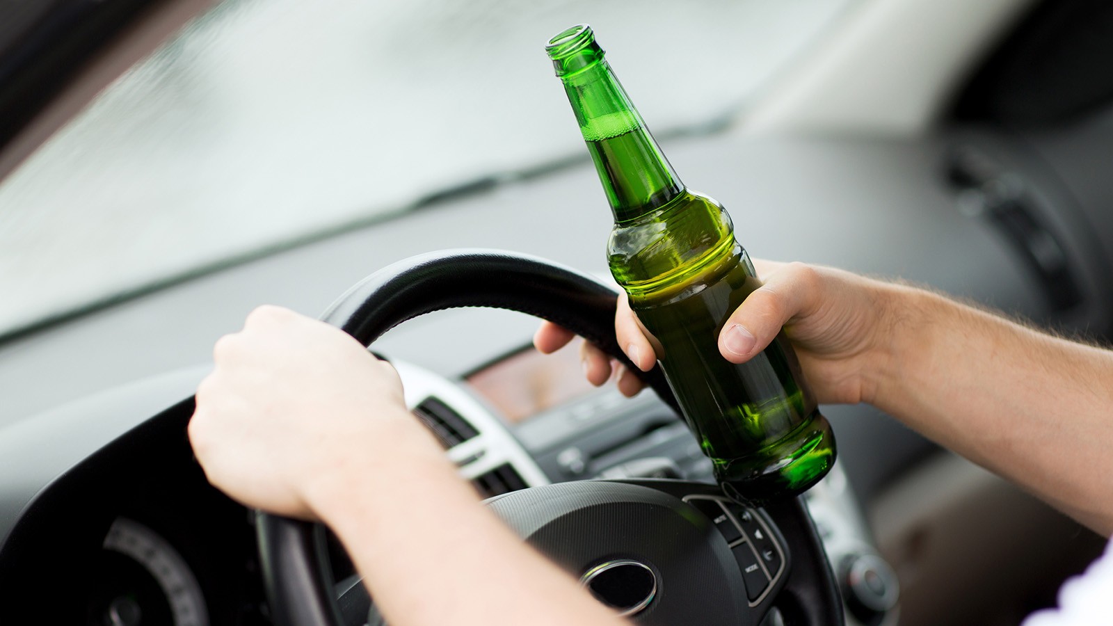 man drinking alcohol while driving the car