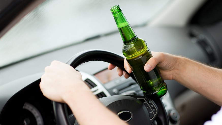 man drinking alcohol while driving the car
