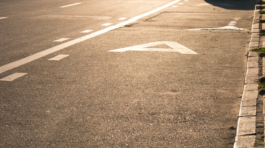 Asphalted traffic lanes against the sun during sunset