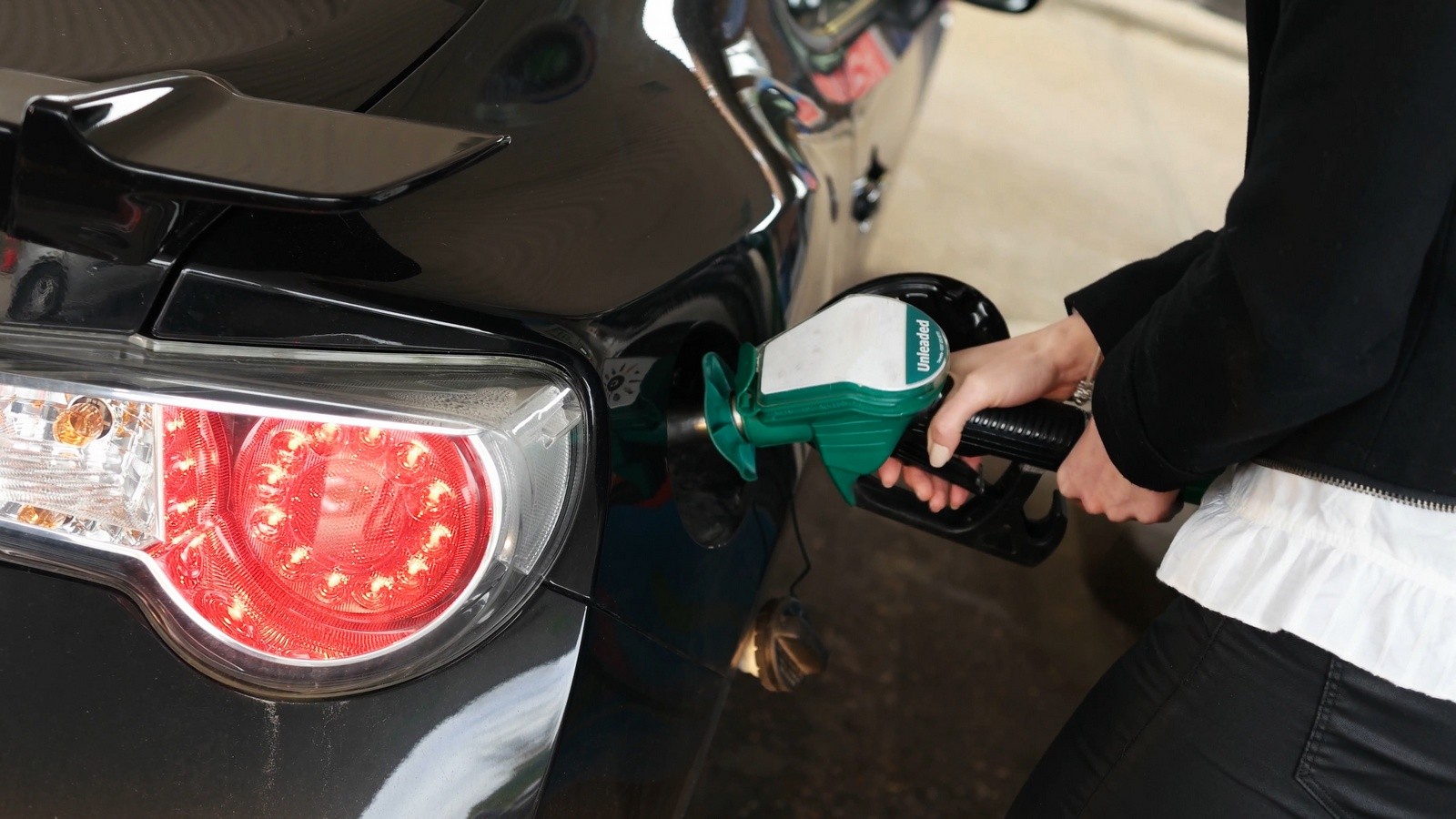 Woman dispensing fuel from a petrol pump