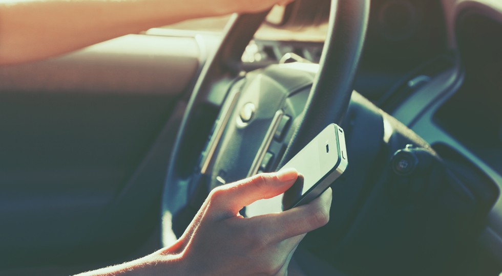 girls hand using smart phone while car driving