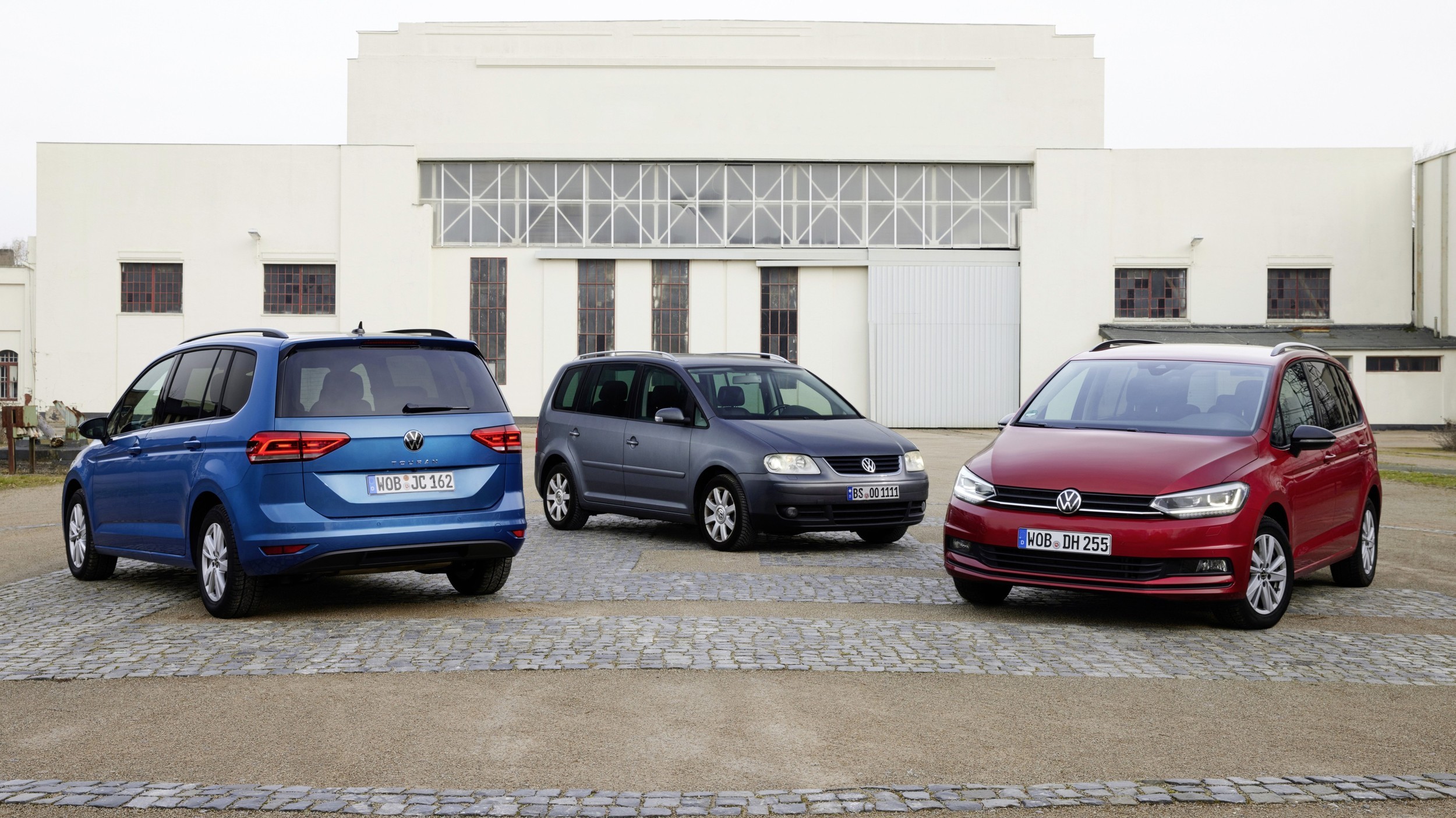 VW Touran первого поколения (в центре) и второго поколения (по краям)