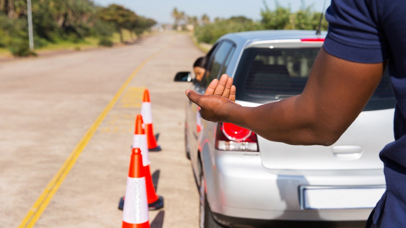 driving instructor teaching young girl to reverse