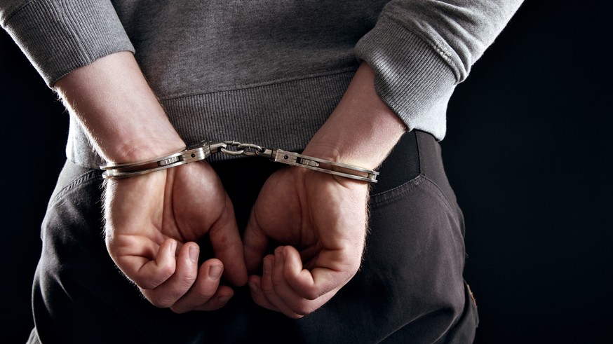 Outlaw's Hands Locked in Handcuffs