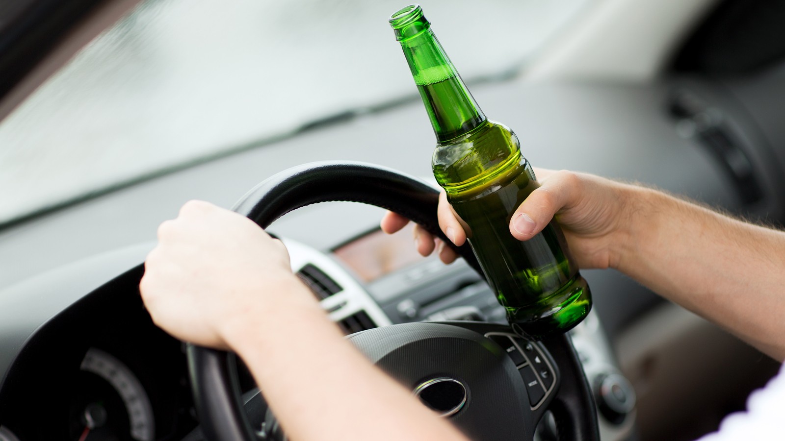 man drinking alcohol while driving the car