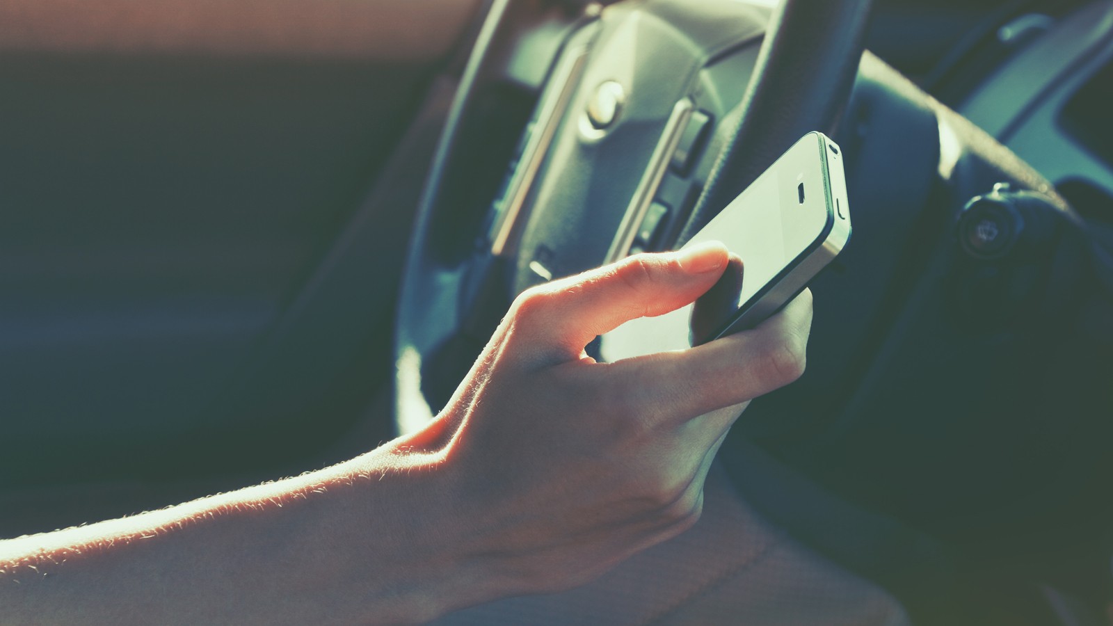 girls hand using smart phone while car driving