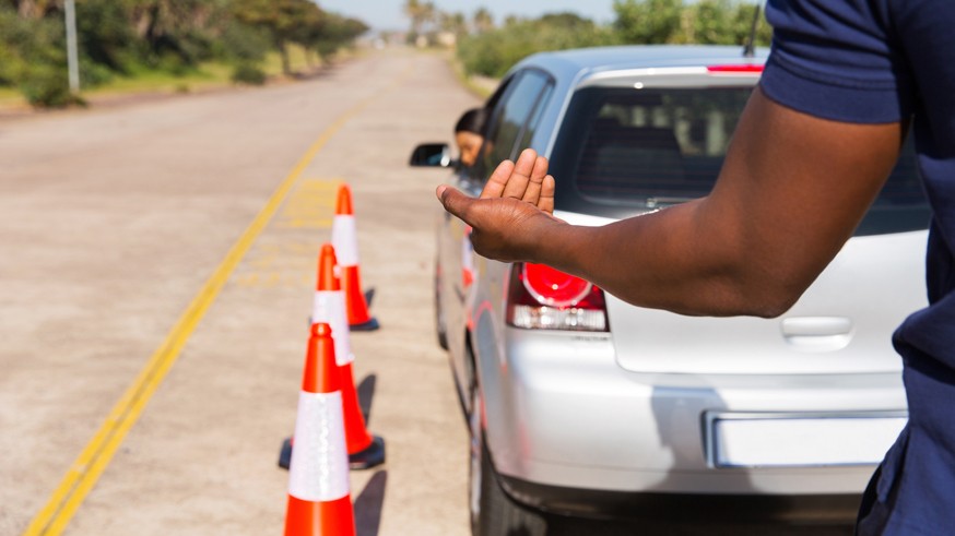 driving instructor teaching young girl to reverse