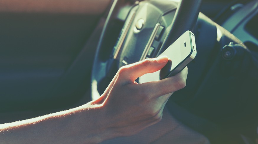 girls hand using smart phone while car driving