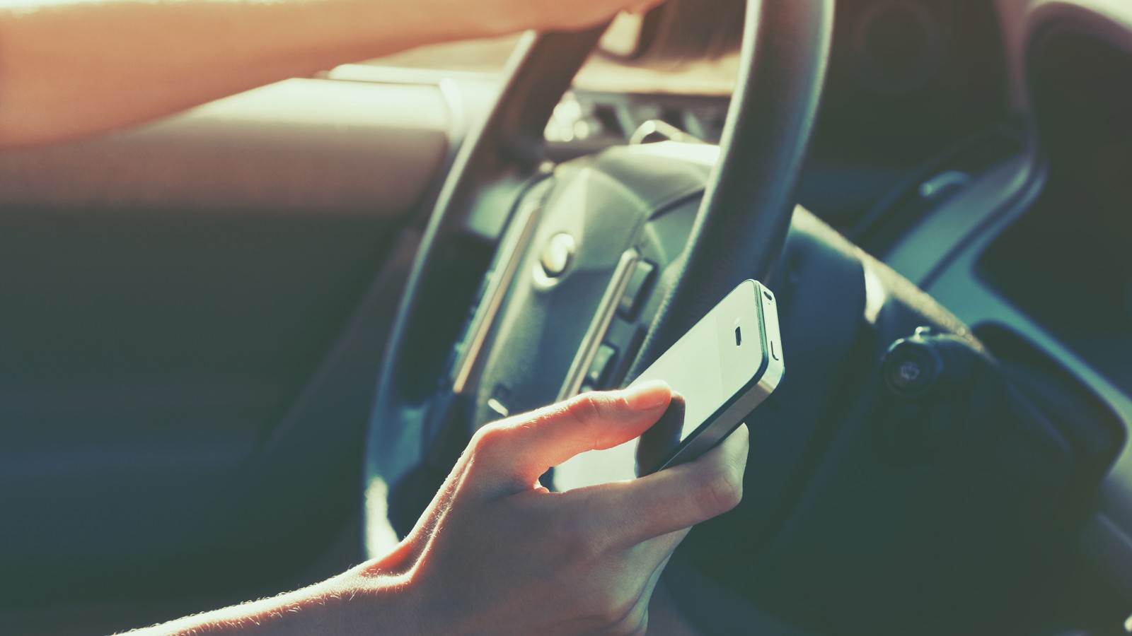girls hand using smart phone while car driving