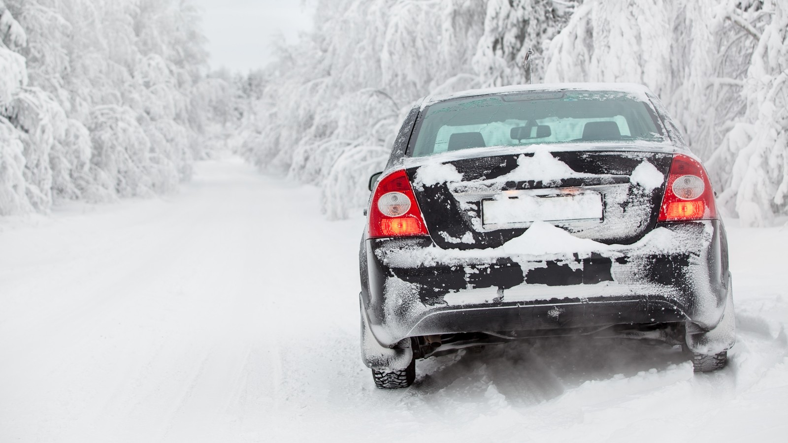 Winter white road with black vehicle standing at roadside