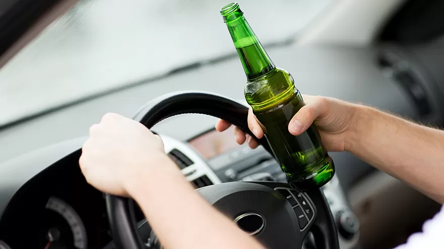 man drinking alcohol while driving the car