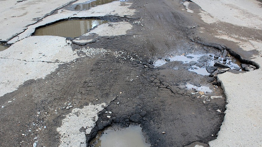 road with potholes and puddles