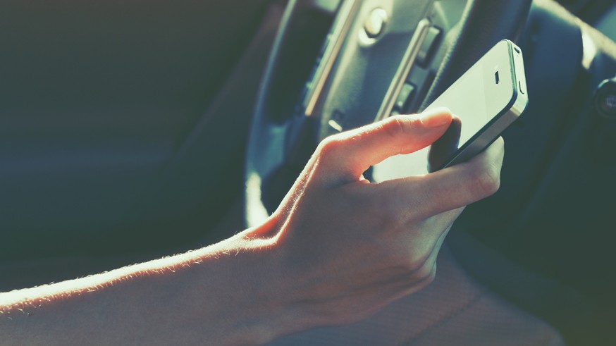 girls hand using smart phone while car driving
