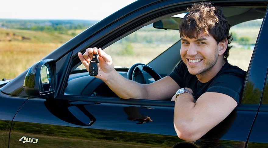 happy man showing keys in car