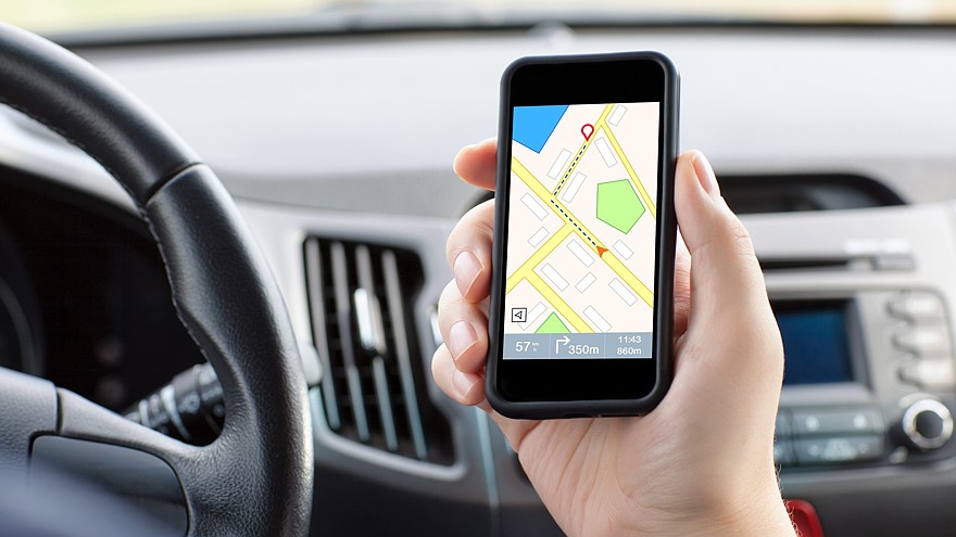 man sitting in the car and holding a phone with interface naviga