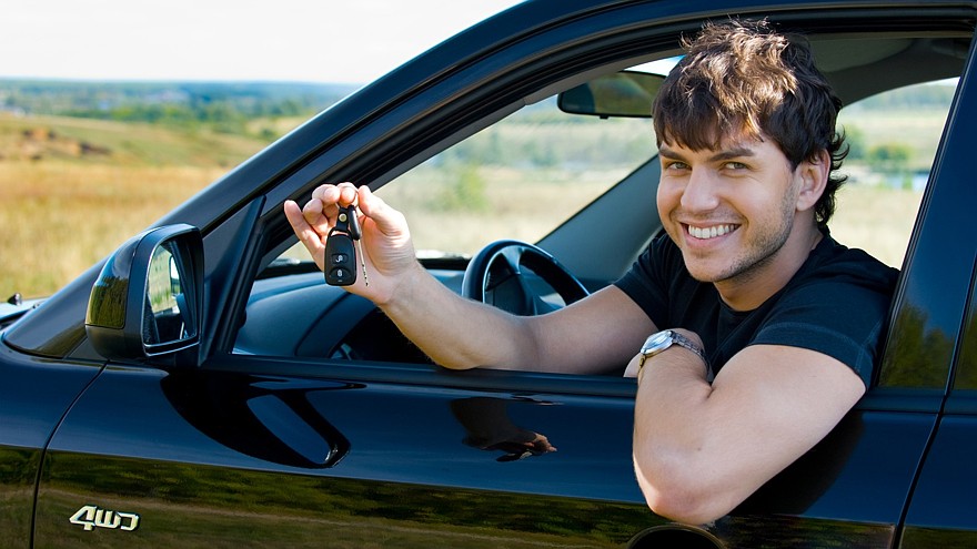 happy man showing keys in car