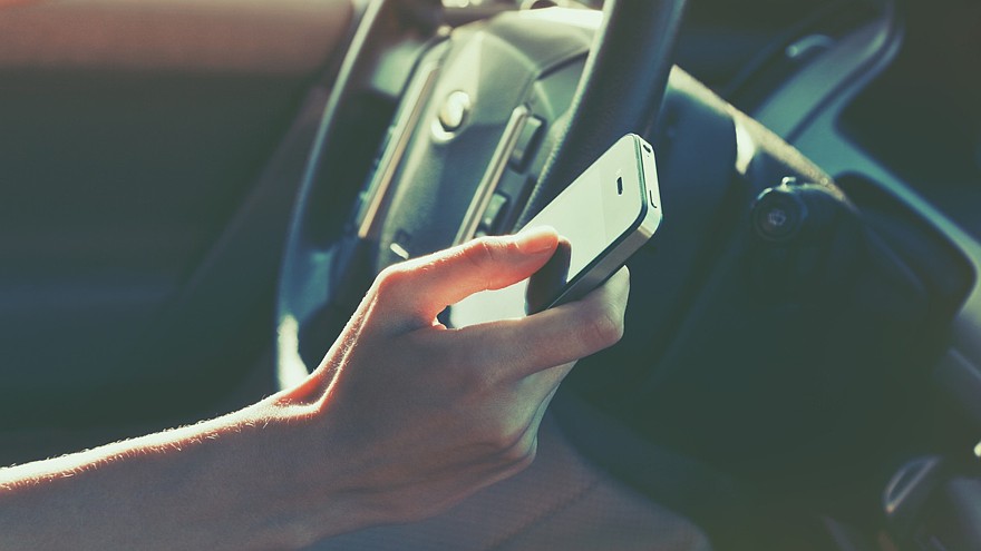 girls hand using smart phone while car driving